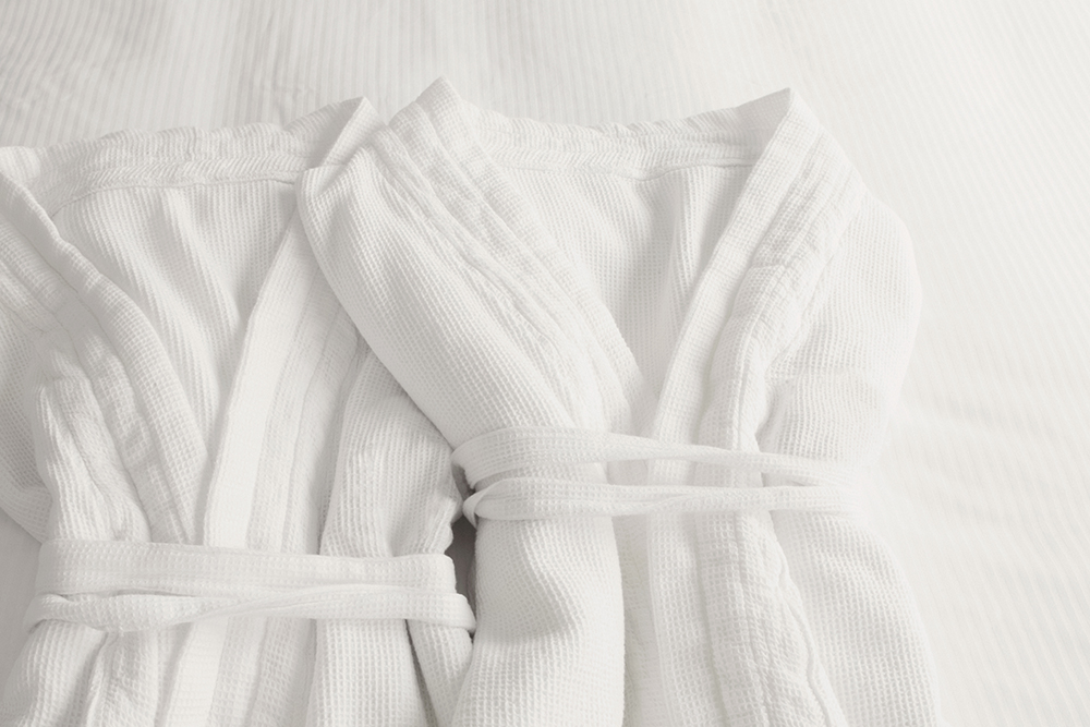 High angle view of two bathrobes on the bed