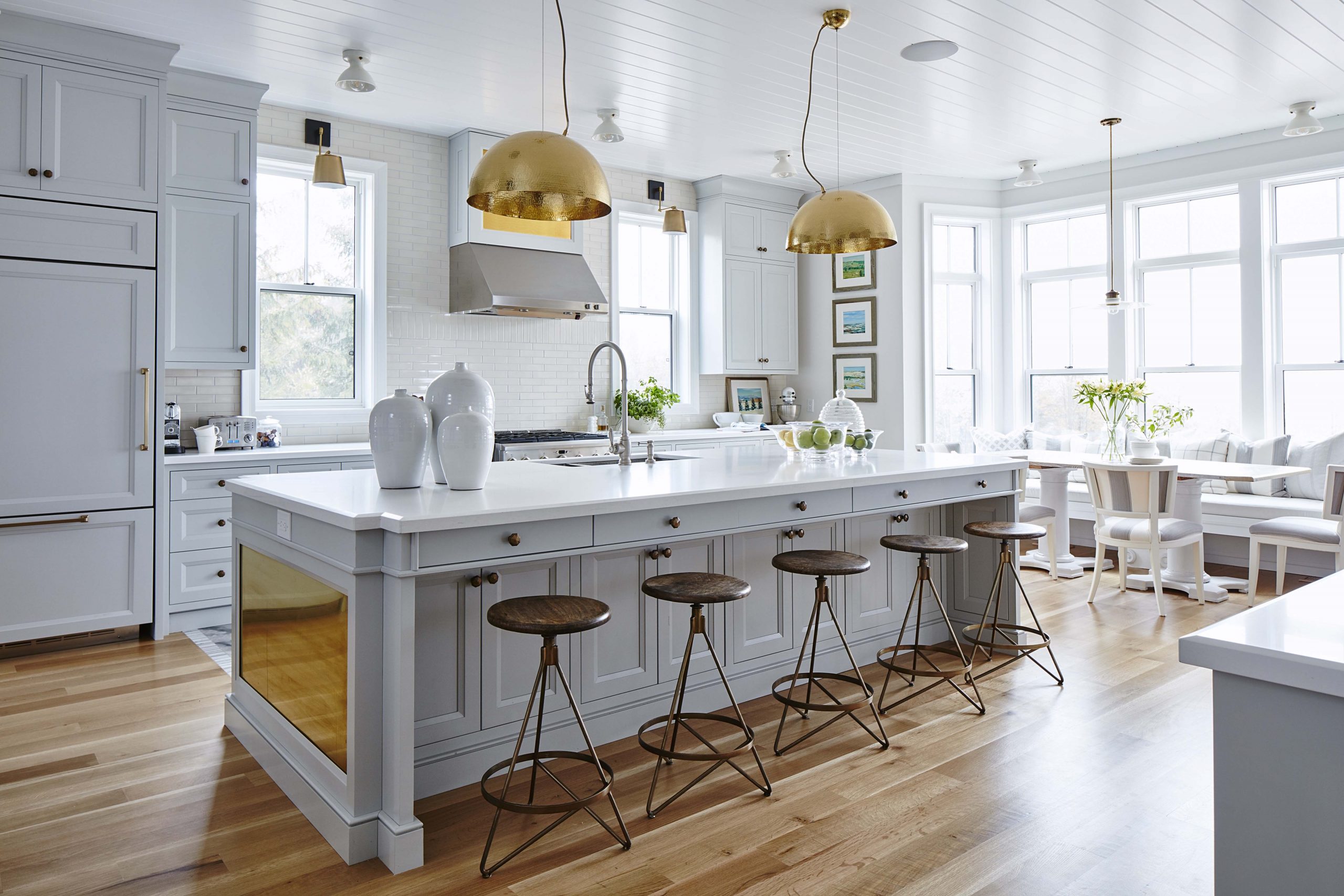 white kitchen with brass island plates and lights