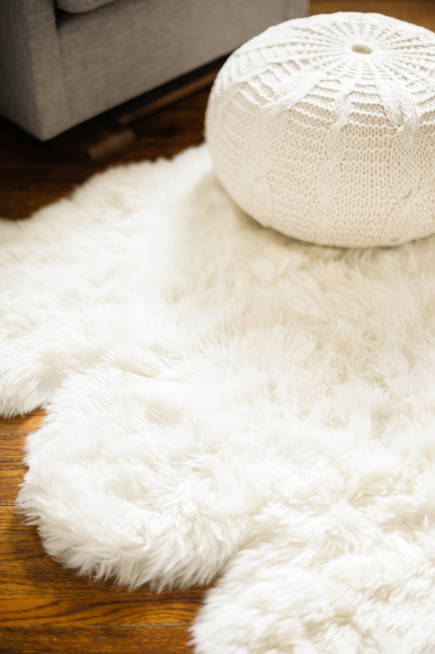 Lush white pouf on white fake fur rug