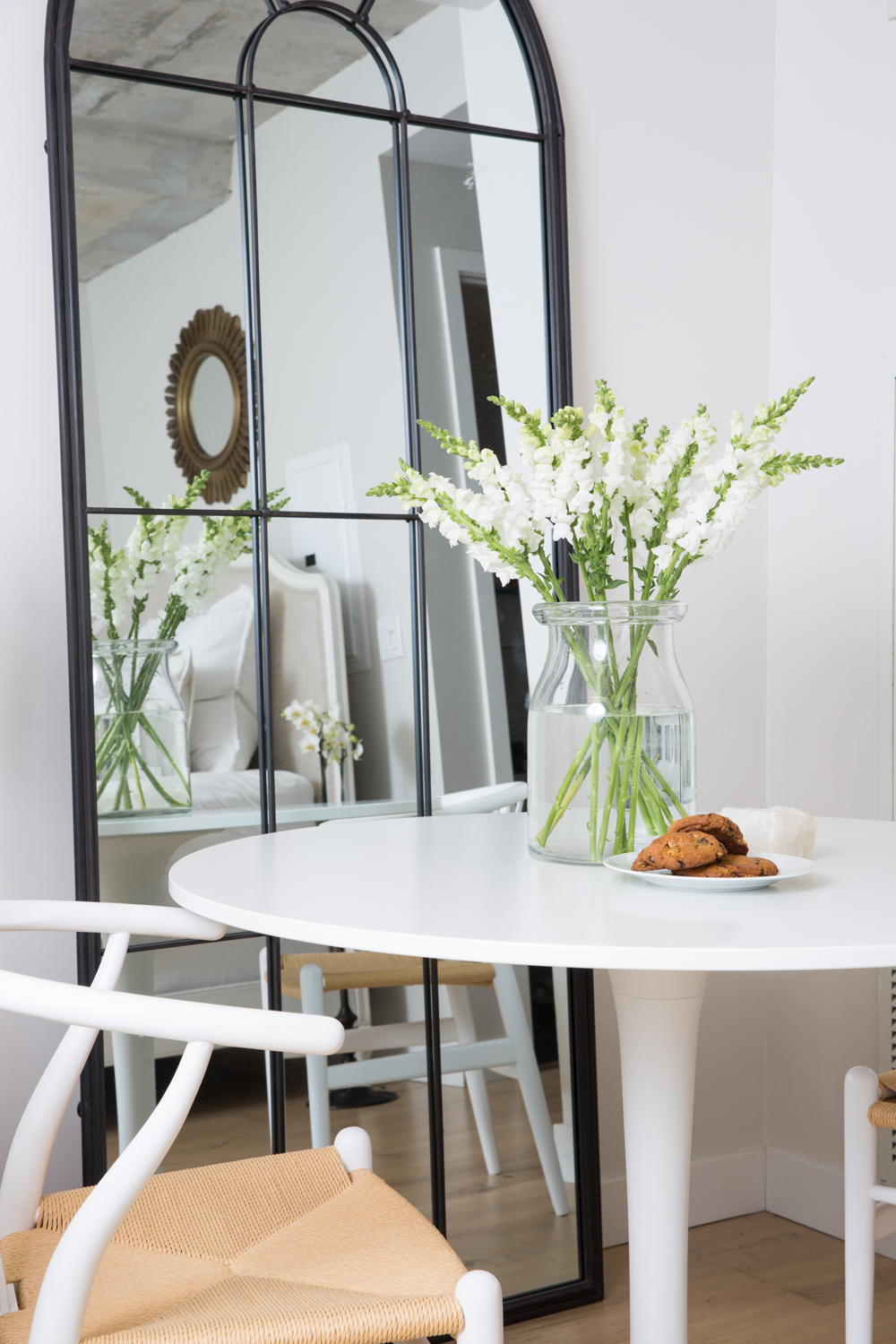 Mirror against white wall with a small table in the forground