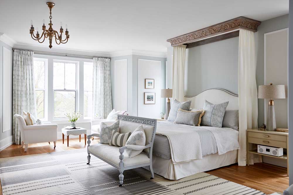 Neutral bedroom with brass chandelier and plenty of seating areas