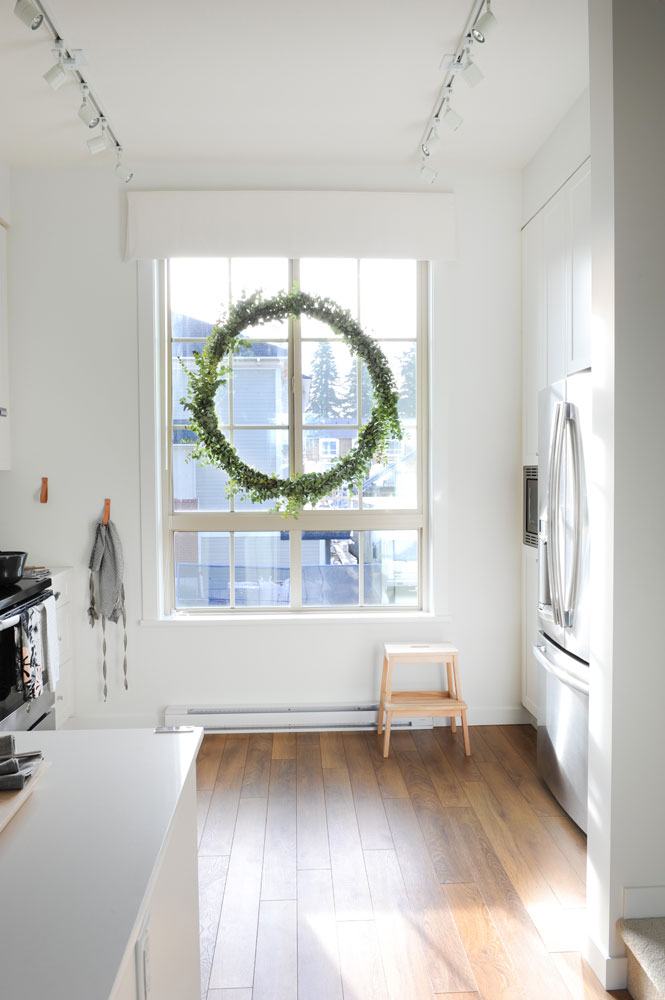 sunny kitchen window with large plain great wreath in it
