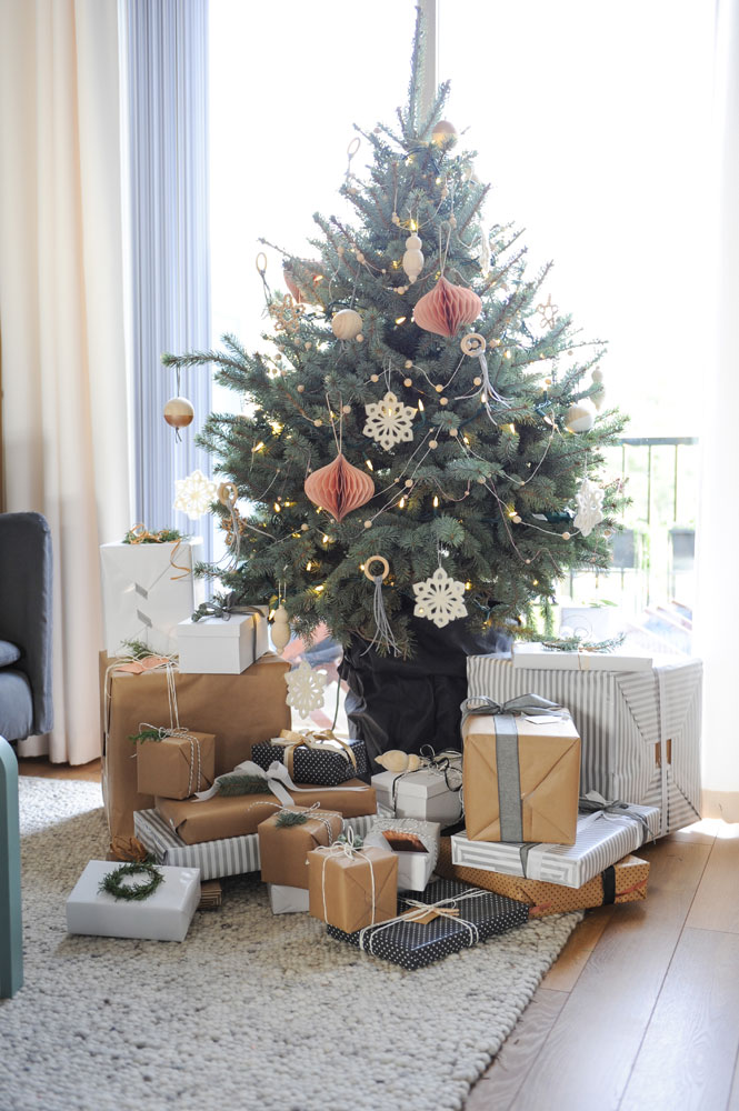 small xmas tree in window, presents in kraft paper and grey and white stripes,