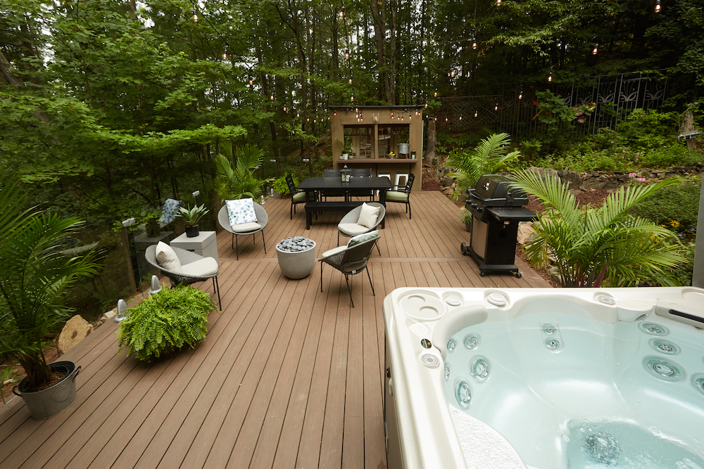 backyard beer garden with brown deck, bar, seating area, dining area and hot tub