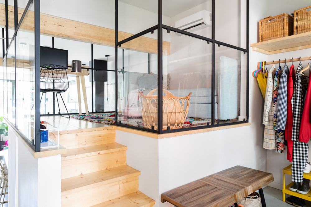 A small glass alcove in a unique, open-concept loft with all-glass walls and small furniture