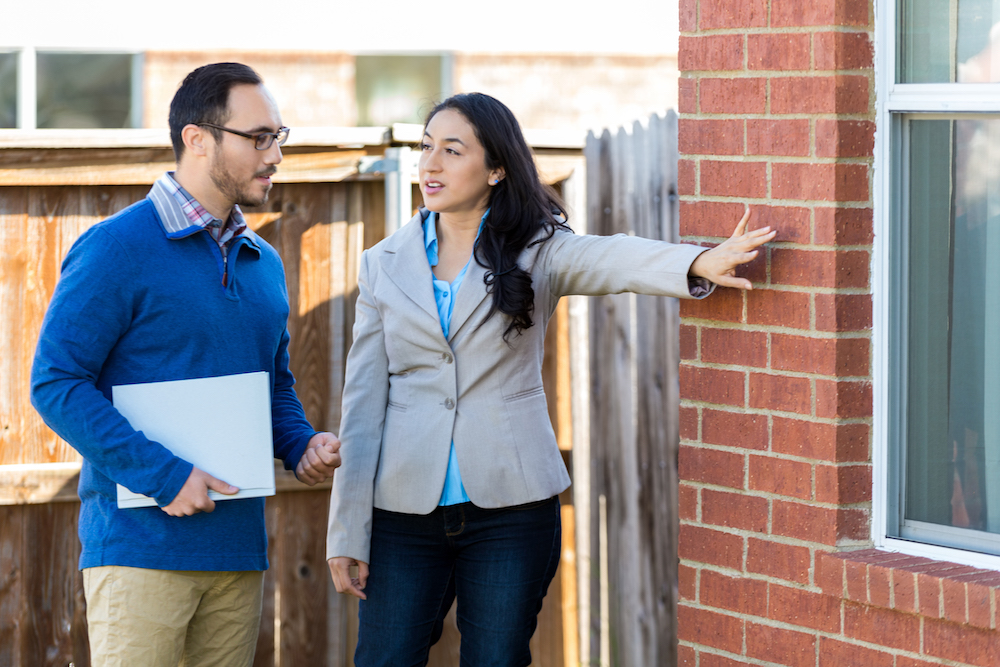 Home inspector or real estate agent examines home
