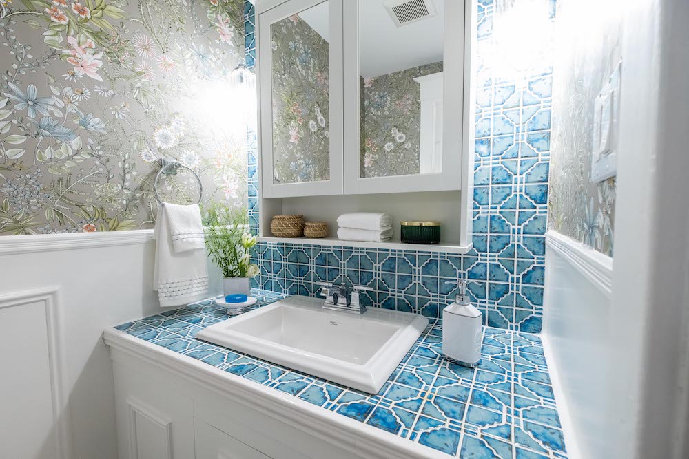 colourful powder room with floral wallpaper and blue-tiled backsplash and countertop