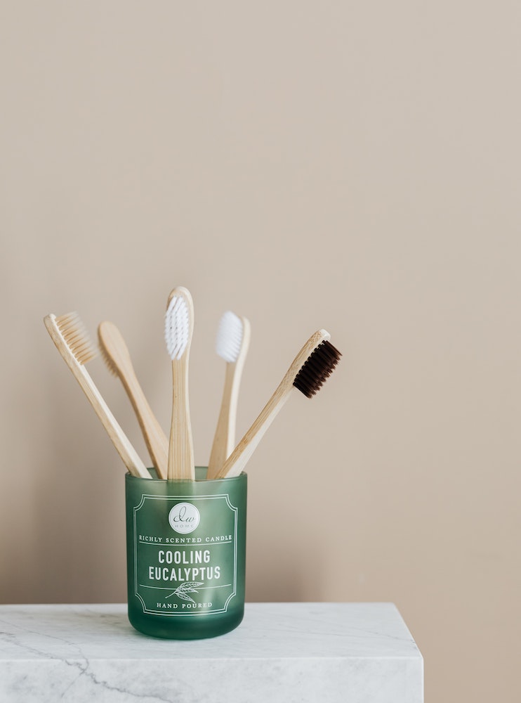 wooden toothbrushes in small green container