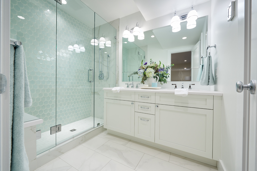spacious white bathroom with aqua shower tiles