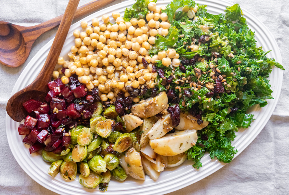 A large plate of an epic kale winter salad with beets, Brussels sprouts and chickpeas
