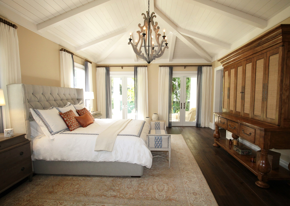 A master bedroom with wood beams in a unique pattern and shiplap ceiling