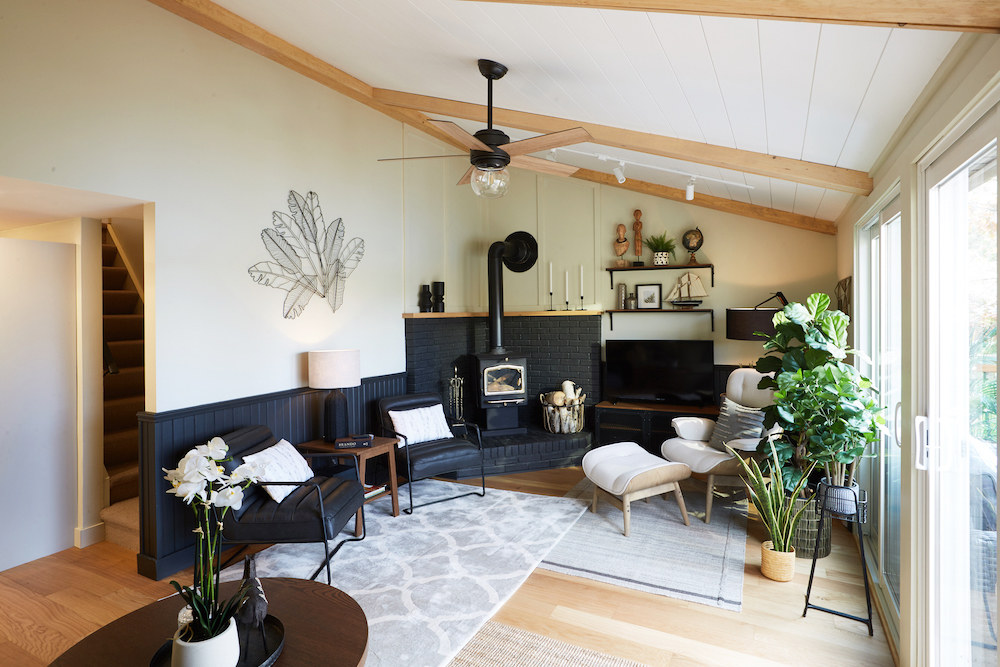 A cabin-inspired living room with a bright-white shiplap ceiling and faux wood beams