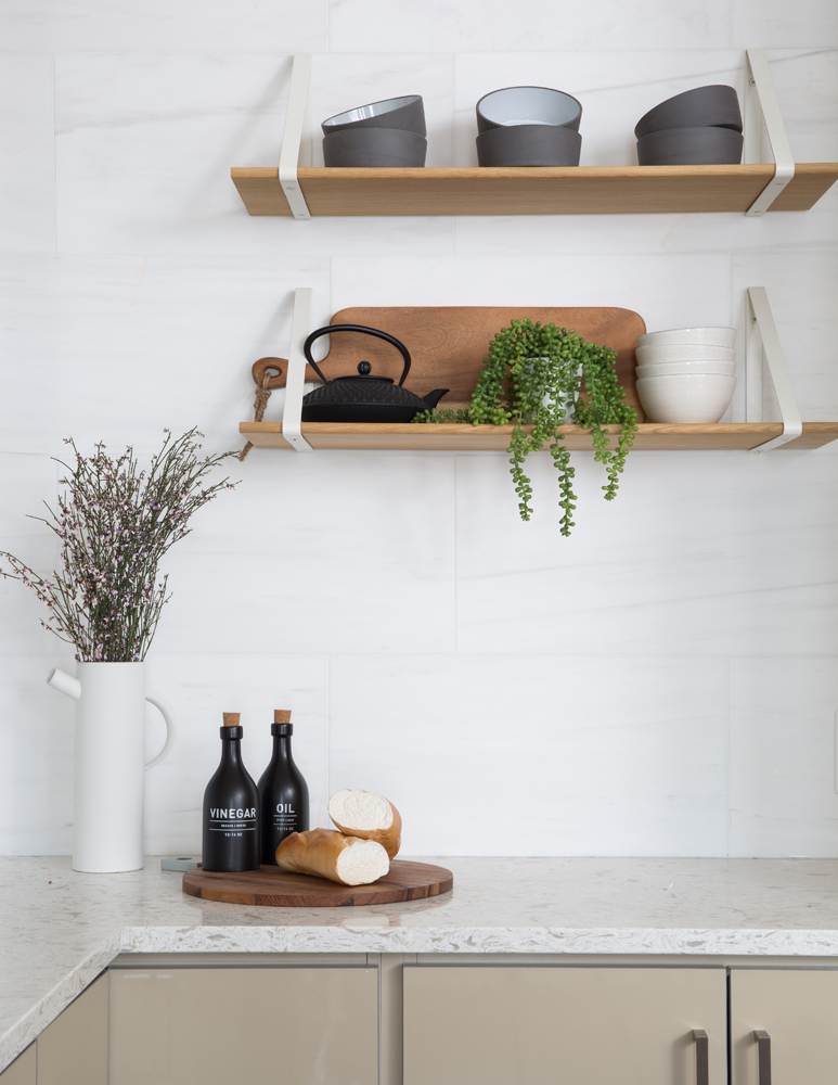 Kitchen wall with two wood shelves with plant on bottom shelf
