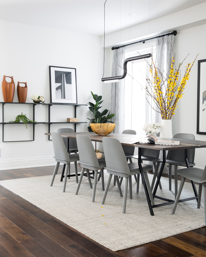 Dining room with grey chairs and hanging black wall unit