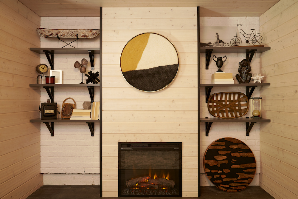 wood-panelled walls with exposed brick, open shelves and round art over fireplace