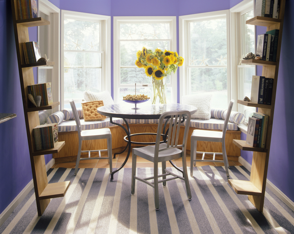 Small purple dining room with bay window blue-and-white striped rug