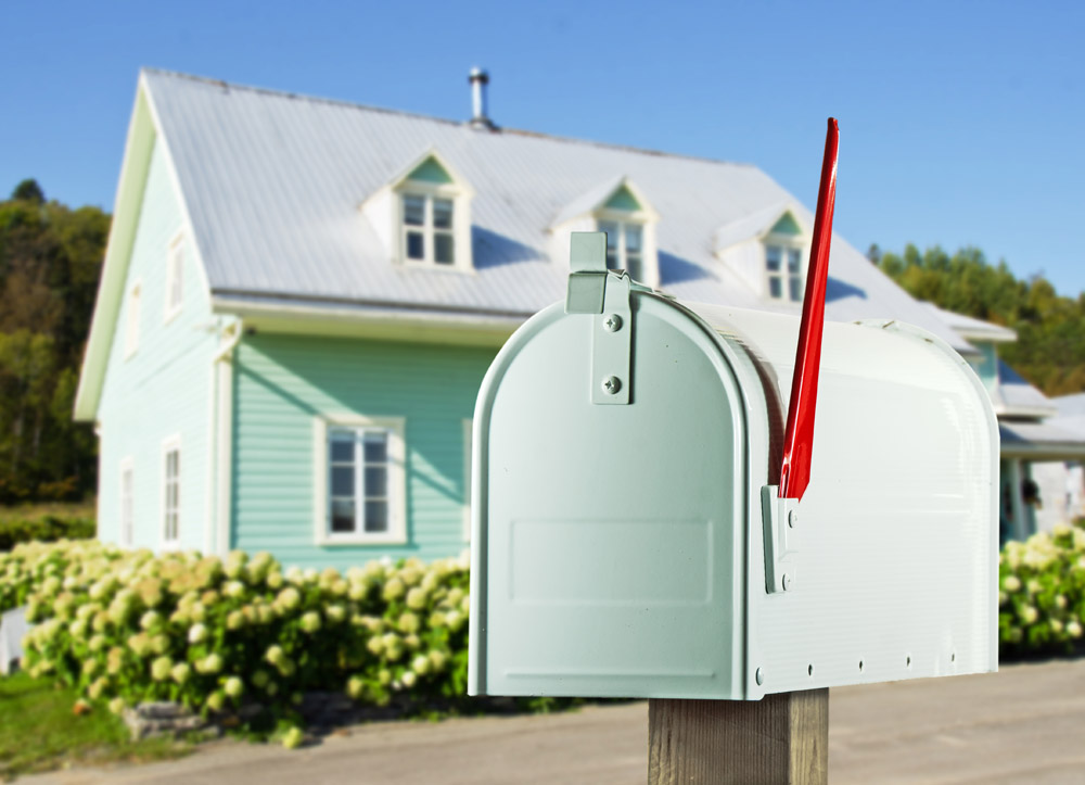 A pale blue mailbox outside a house