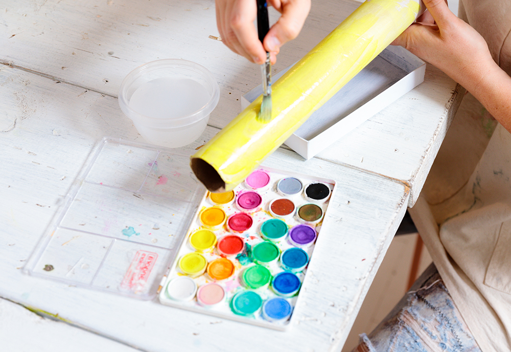 Tiffany Pratt painting a tube with yellow watercolour paint