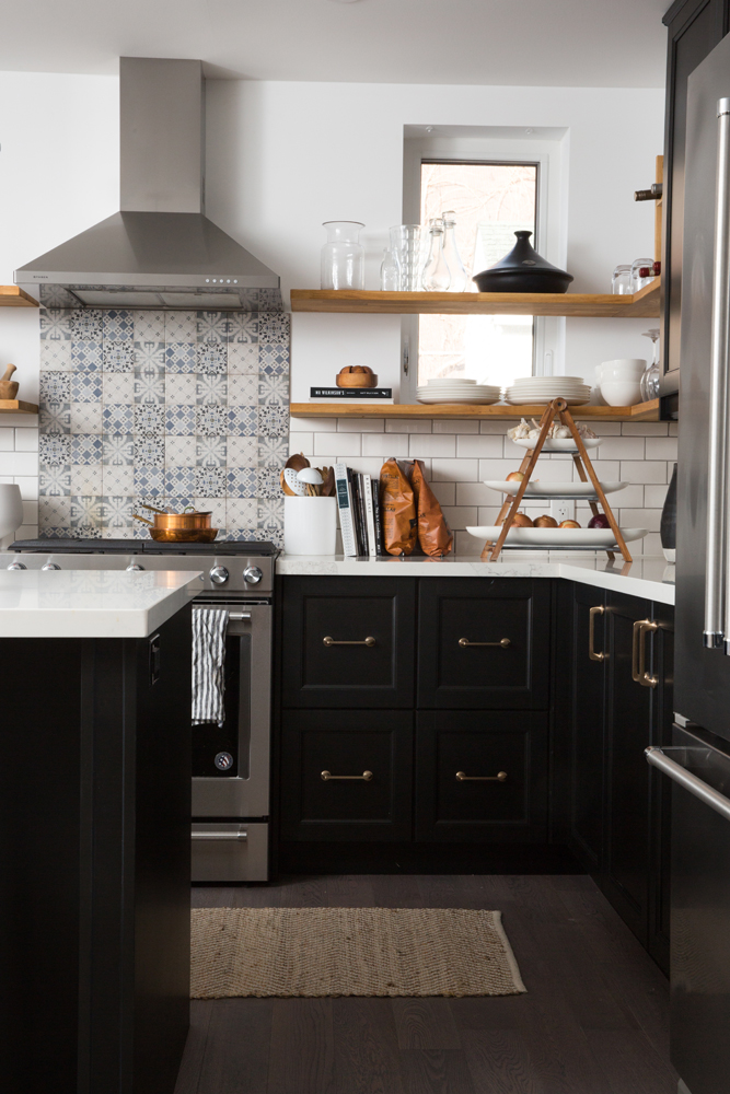 Modern meets rustic kitchen with black lower cabinets and patterned backsplash
