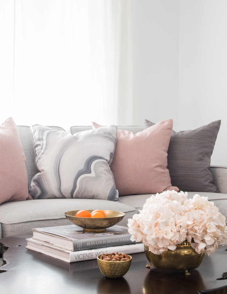close up of grey and pink pillows on grey sofa