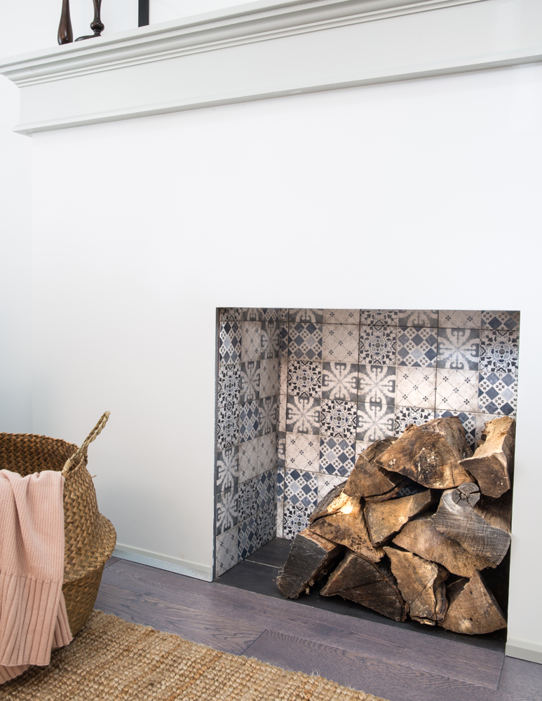 Close up of tiled fireplace place insert with log pile
