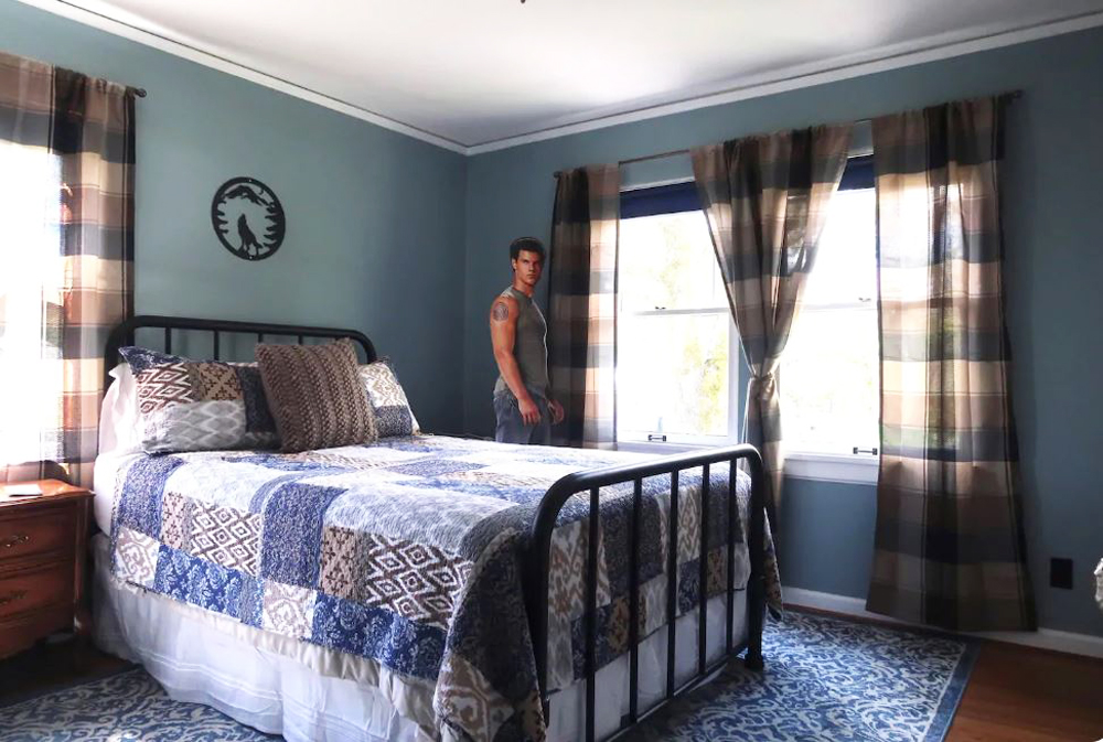 A blue bedroom with a cardboard cutout of actor Taylor Lautner as Jacob from the movie Twilight