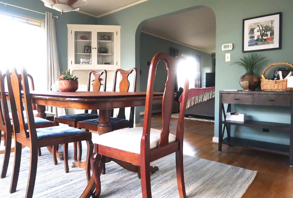 A vintage green dining room with wood table