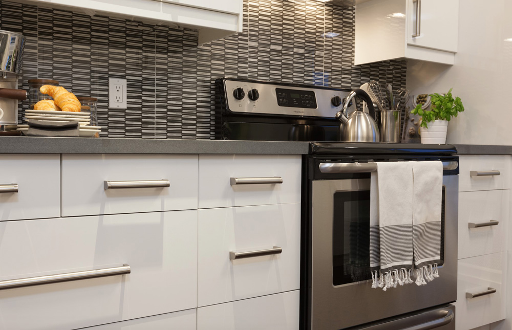 A sleek kitchen countertop with oven and tiled backsplash