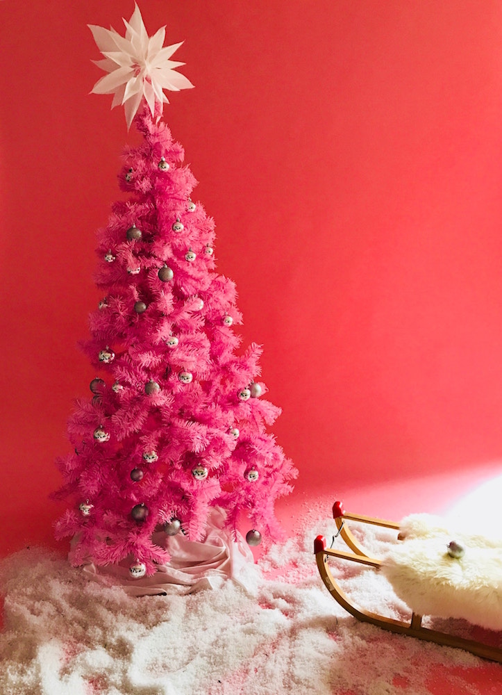 hot pink christmas tree with silver ornaments in red room