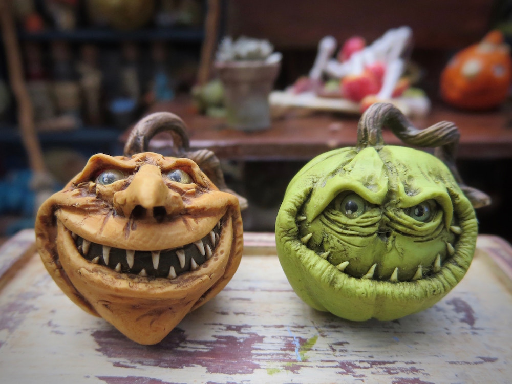 green and an orange pumpkins with realistic faces