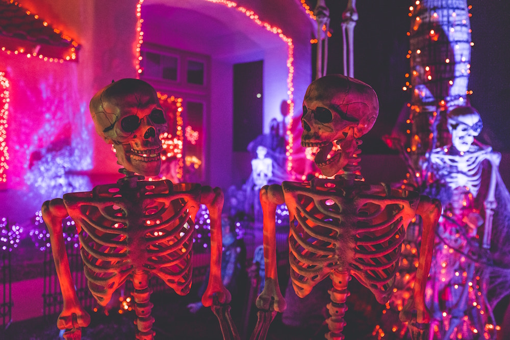 skeletons in front of lighted house