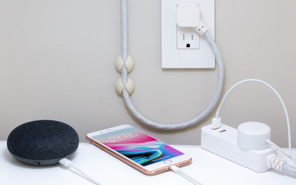 electronics chargers plugged into outlet on white wall