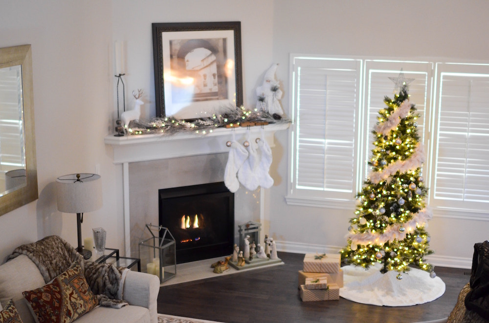 white living room with fireplace and small tree with white decorations