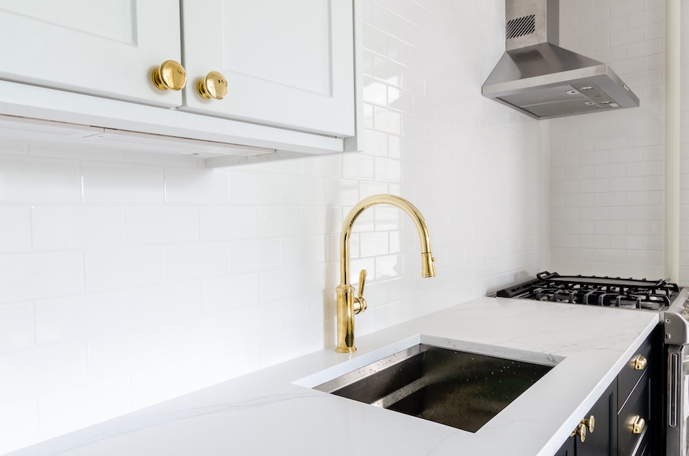 White kitchen with gold faucet and gold finishing