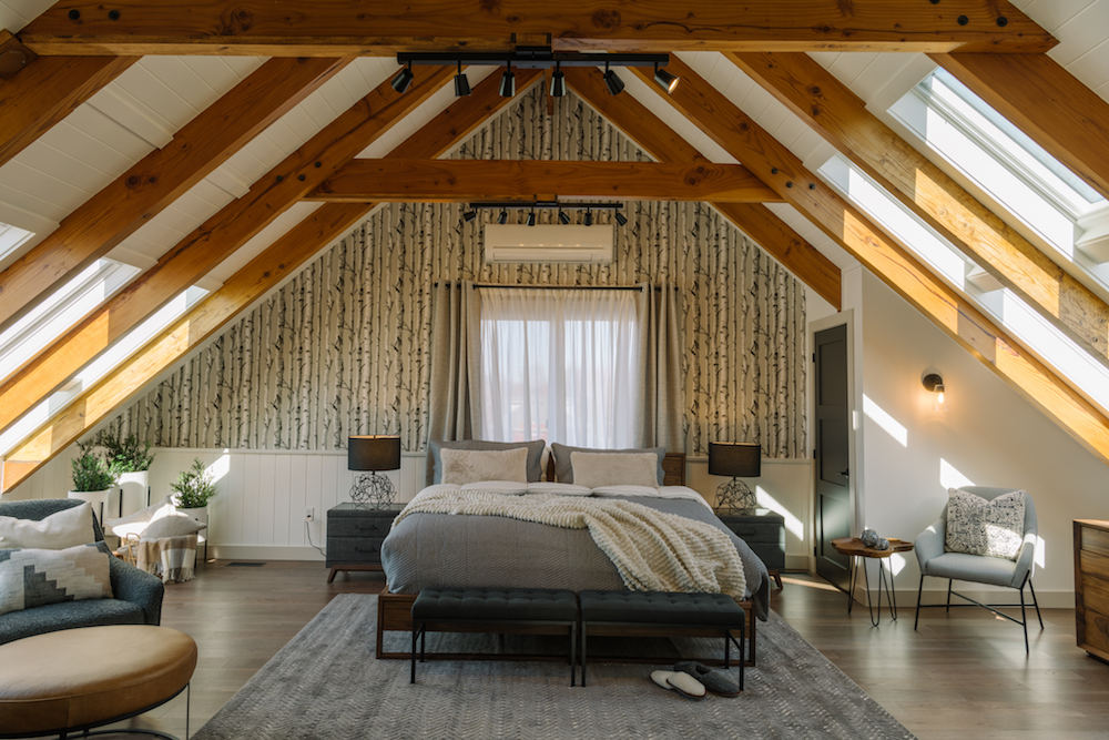 Spacious cottage bedroom with high ceilings and wooden beams