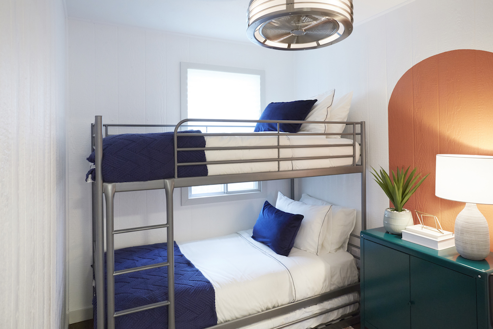 Bunk beds with blue and white bedding and green nightstand