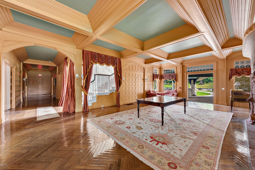 The spacious main lobby with original hardwood flooring, area rugs and window drapes