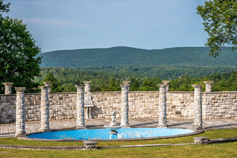 An old stone pool with Corinthian columns and panoramic views of the surrounding scenery