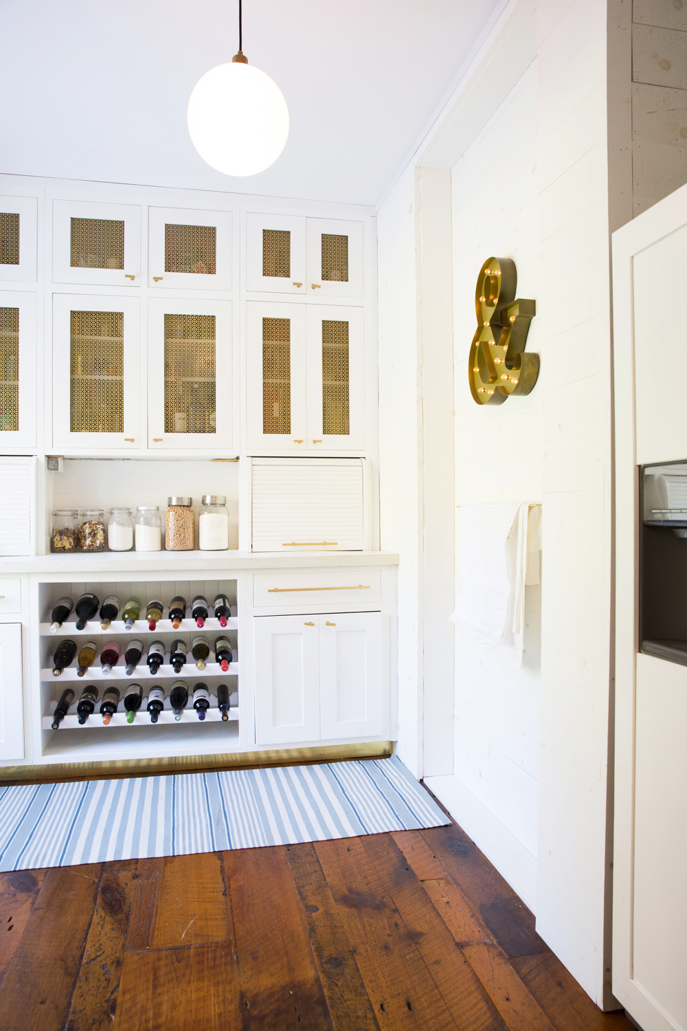 A small walk-in pantry/cantina combination with storage space and wine rack