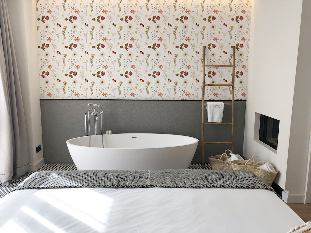Flowered wallpaper near standalone bath tub