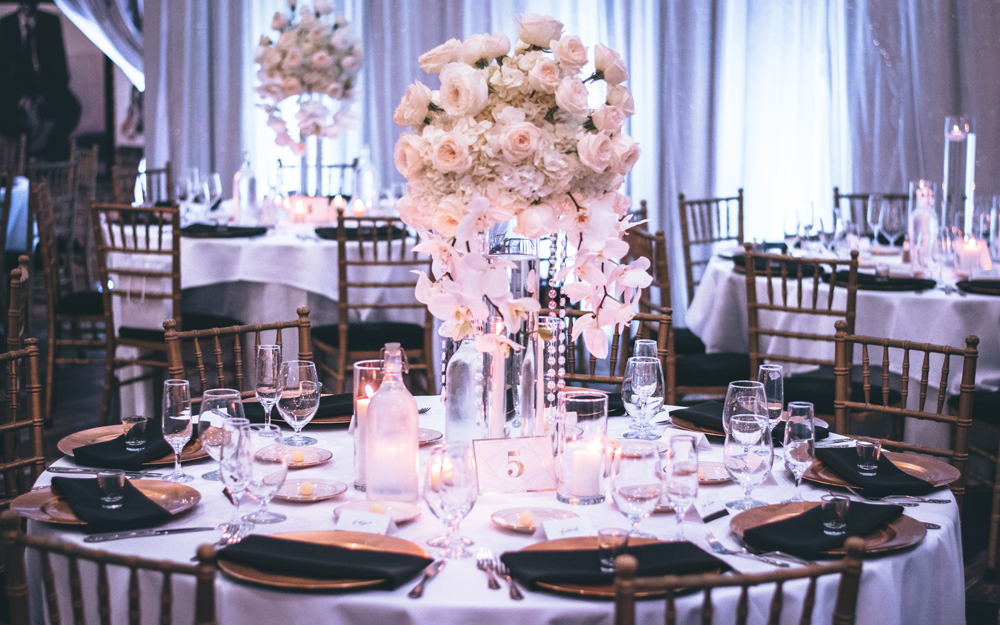 Guest table at a wedding featuring pastel colours with black accents with the napkins