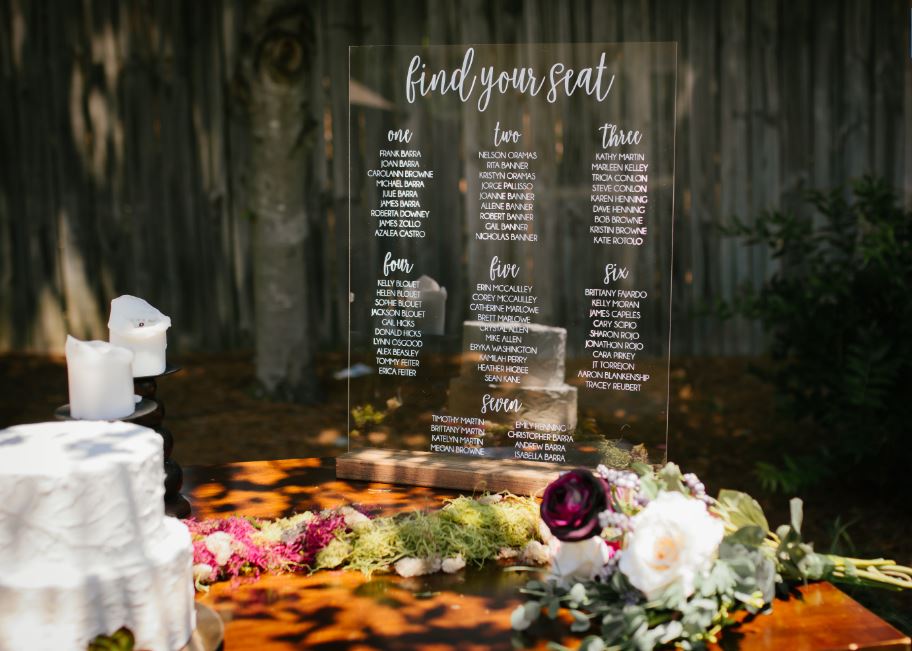 A translucent seating chart at an outdoor wedding