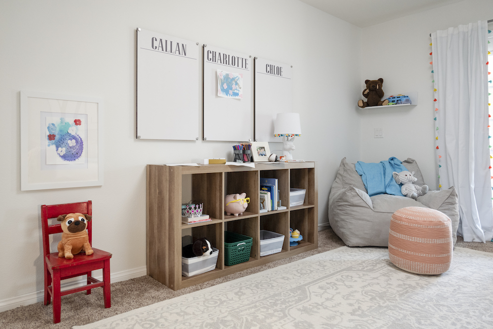 white playroom with brown shelves and white curtains
