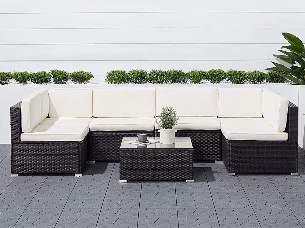 wicker outdoor furniture set with white cushions on grey patio