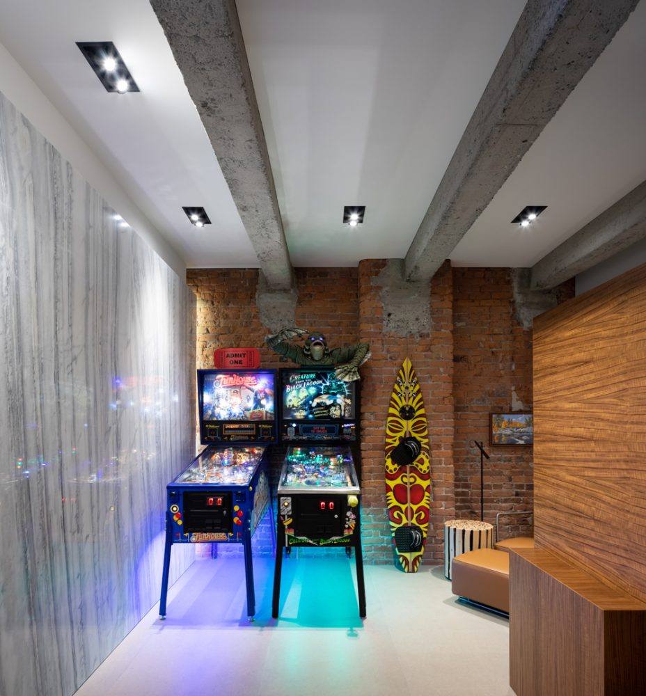 modern games room with two pinball machines and board