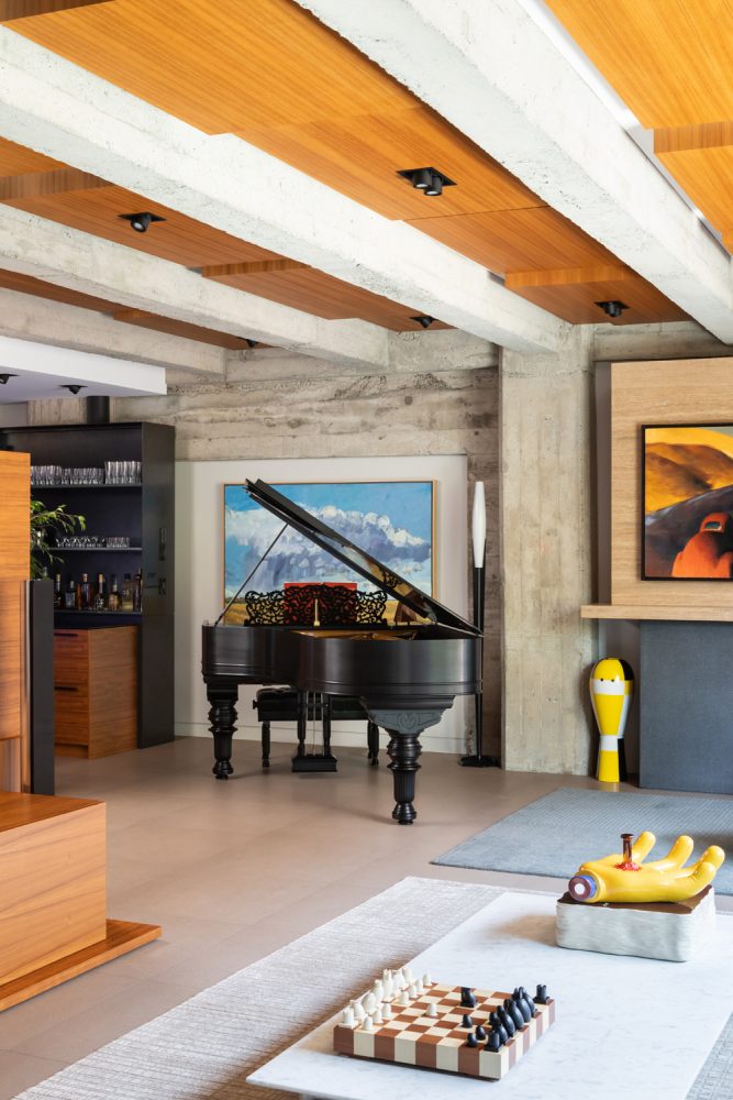 grand piano in modern loft, low slung coffee table with modern chess set and yellow nail hand sculpture