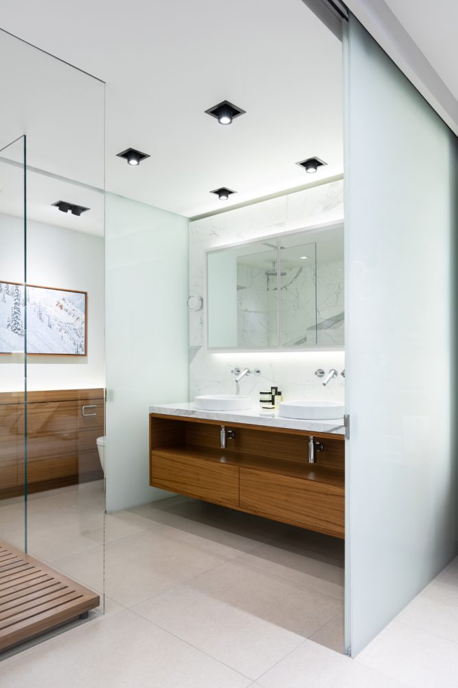 master bath with two vessel sinks on marble and walnut vanity, teak floor shower to the left