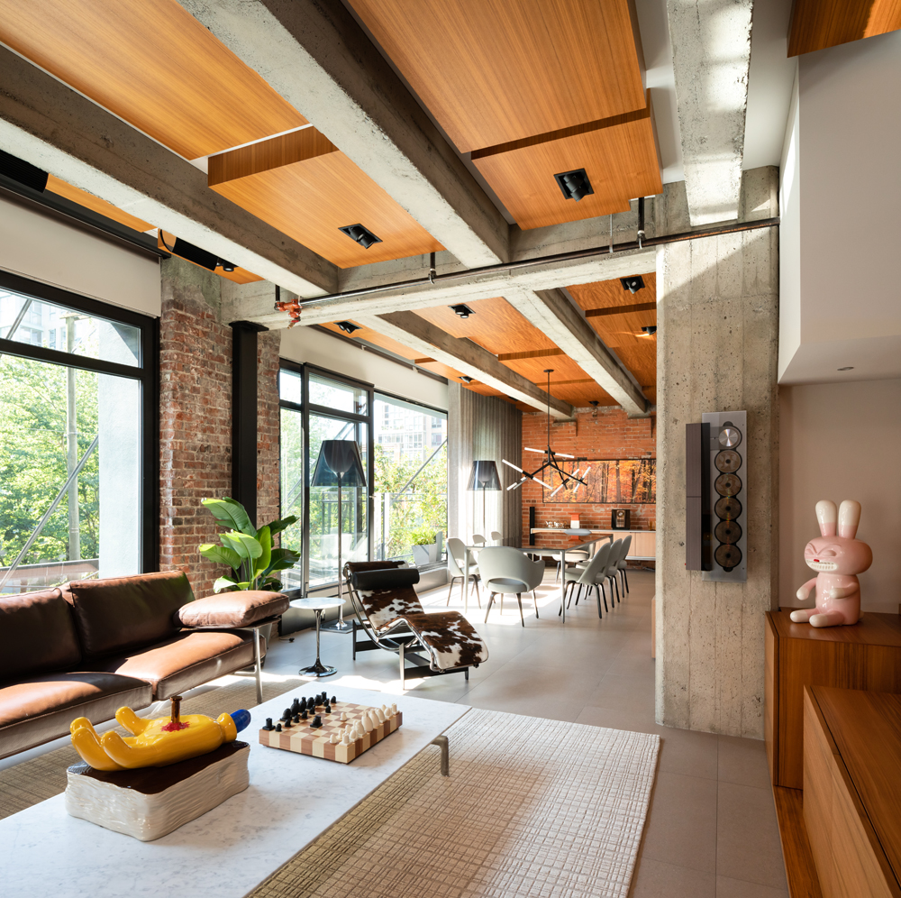 open loft living dining with concrete ceiling beams, wood ceiling, 5 CD player and bunny sculpture to the right