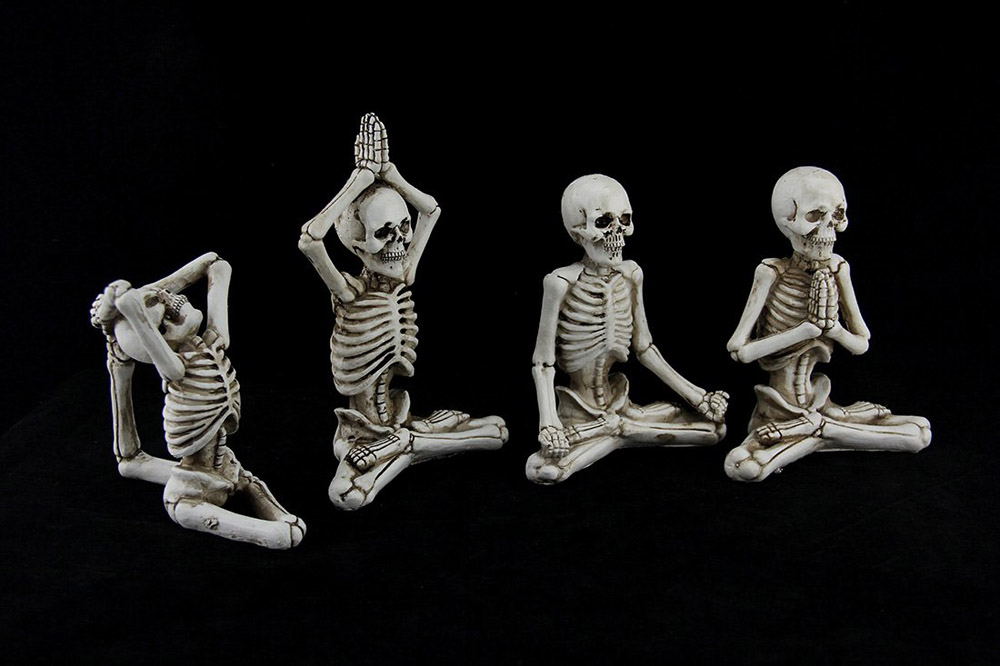 Four little bendable skeletons in yoga poses as Halloween decor