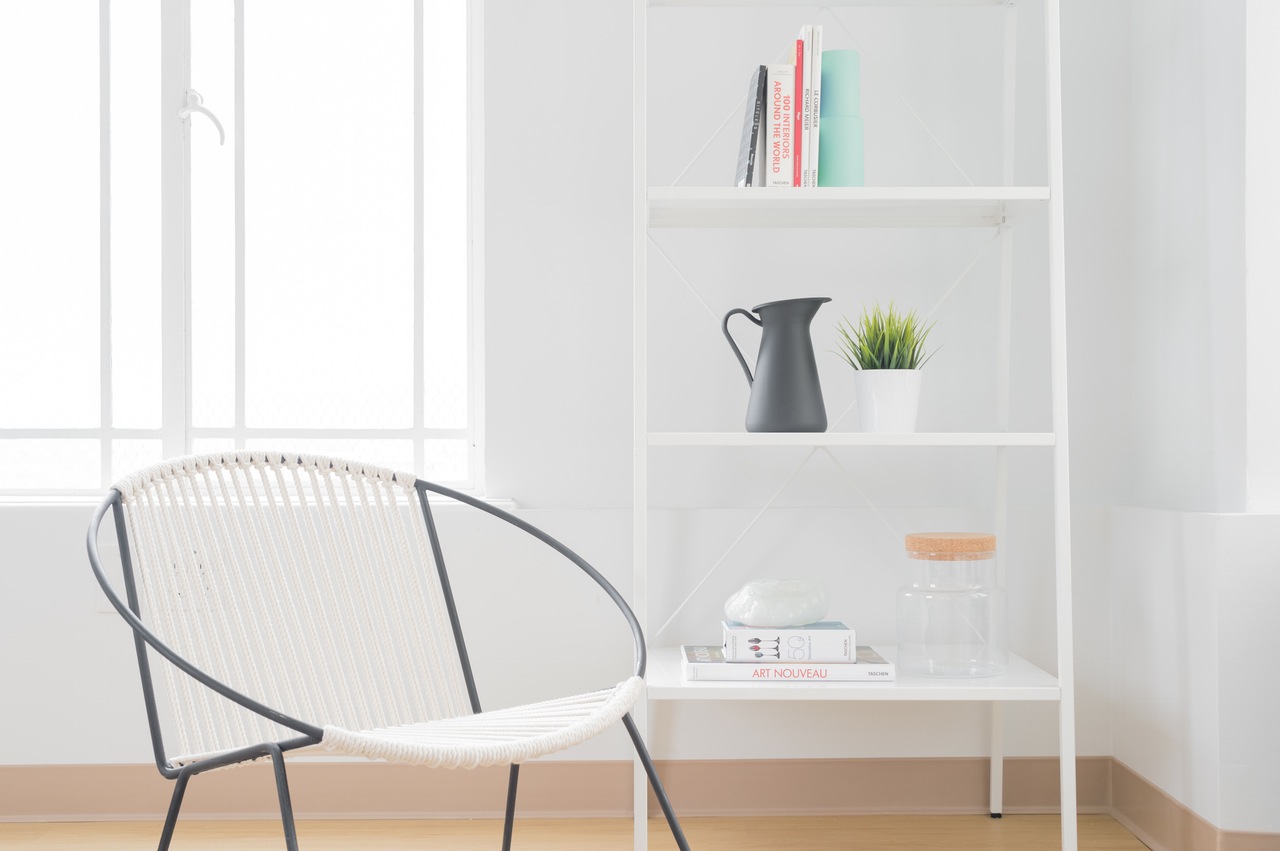 white chair and white shelf in white room